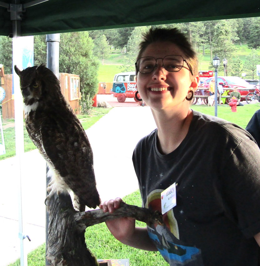 Maddy McFarland shows an owl display at the Evergreen Audubon booth.